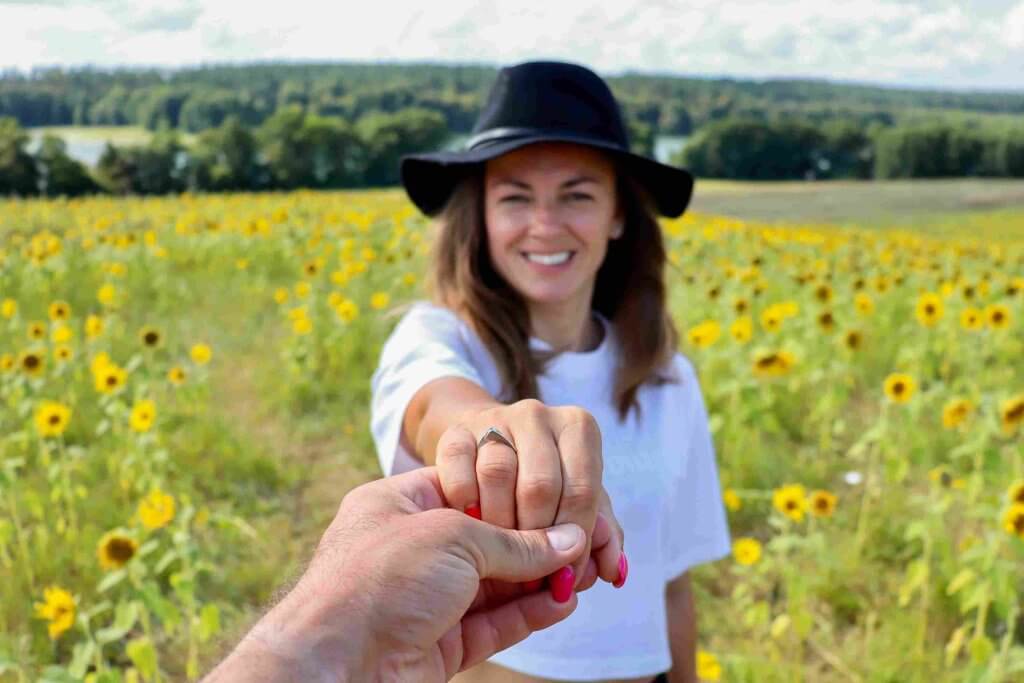 homem segurando a mão de uma mulher com um anel de noivado em seu dedo