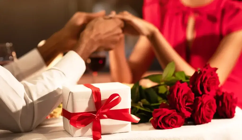 Casal de mãos dadas namorando em restaurante chique